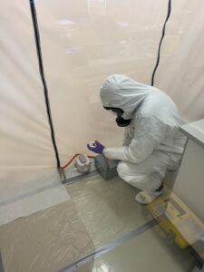 Person in Schutzanzug vor Testraum für Multipass Aerosolversuche am OFI