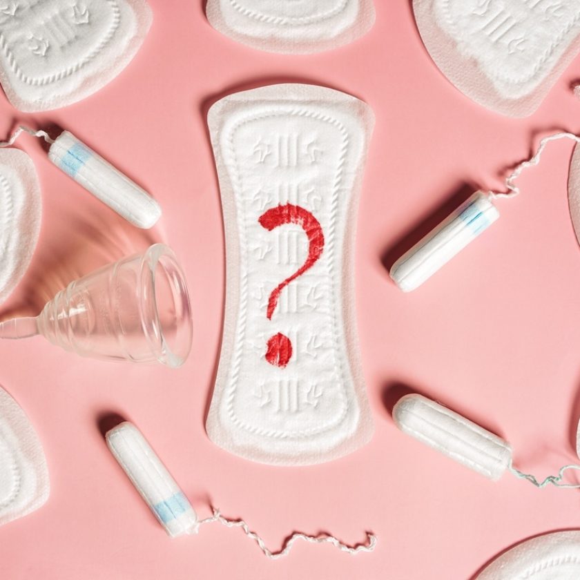 Various menstrual products (tampons, pads, menstrual cups) on a pink background