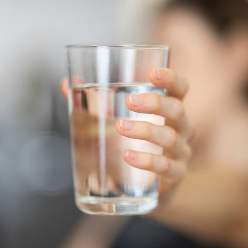 engin-akyurt-PCpoG06fcUI-unsplash_WEB Eine Hand hält ein Glas Wasser